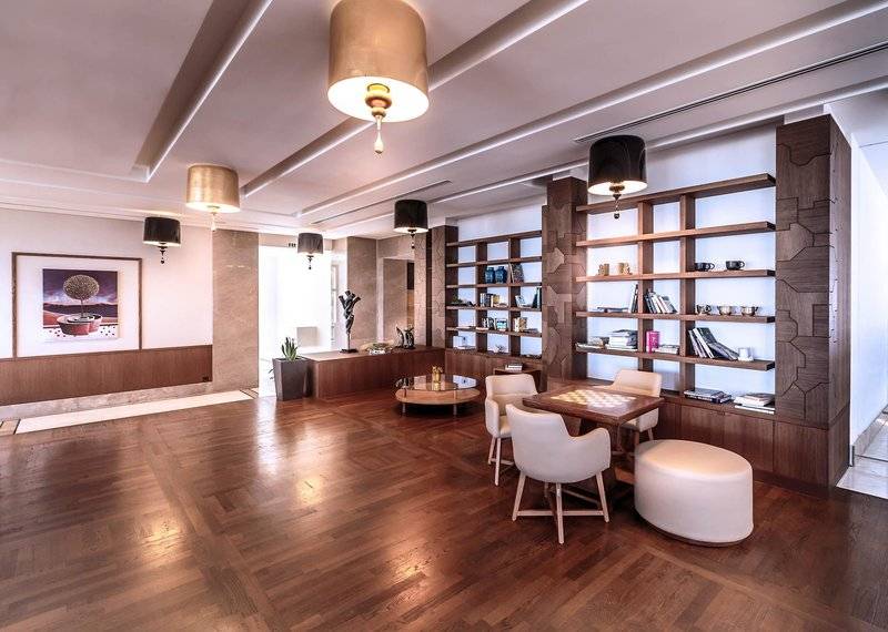 Lobby des Miraggio Thermal Spa Resorts mit Holzboden, weißen Stühlen und Tischen.