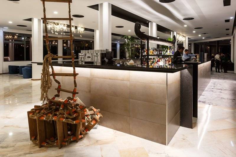 Rezeption Bereich im Baia Azul Hotel mit einer Bar, einer Leiter und einem Fischboot Dekor.