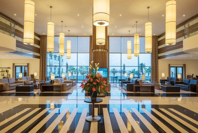 Lobby des Vila Galé Santa Cruz Hotels mit großen Fenstern und modernem Innendesign.