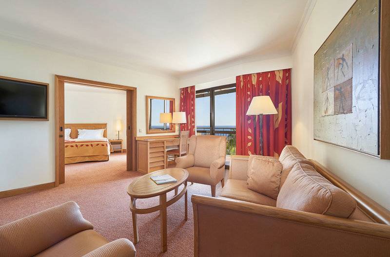 Innenansicht der Suite im Hotel Porto Mare - PortoBay mit Wohnzimmer, Schlafbereich und Blick auf den Ozean.