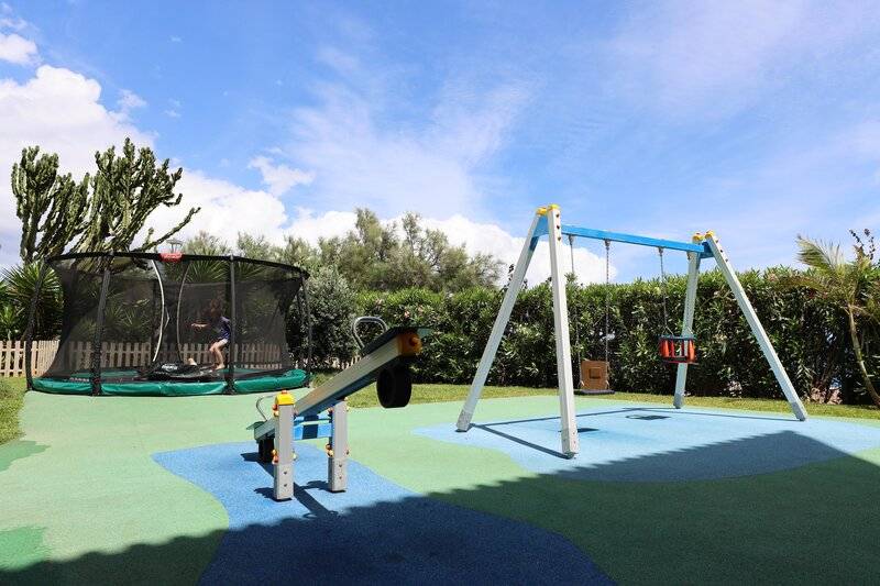 Kinderspielplatz im Freien im The Views Oasis Hotel mit Trampolin, Schaukel und Rutsche.