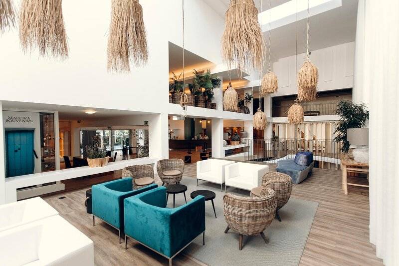 Lobby des The Views Oasis Hotels mit modernen Möbeln, Pflanzen und hängenden Lampen.