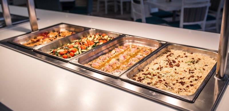 Buffet-Tisch im Views Oasis Hotel mit verschiedenen Gerichten wie Salat, Fleisch und Reis.