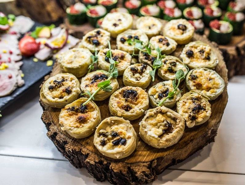 Ein Buffet im Views Oasis Hotel mit gefüllten Artischocken auf einem Holzteller.