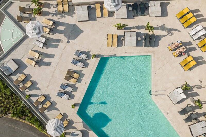 Oberirdischer Blick auf den Pool und die Liegebereiche im The Views Baia Hotel.