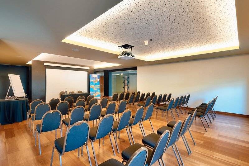 Konferenzraum im Views Baia Hotel mit blauen Stühlen und einer Leinwand.
