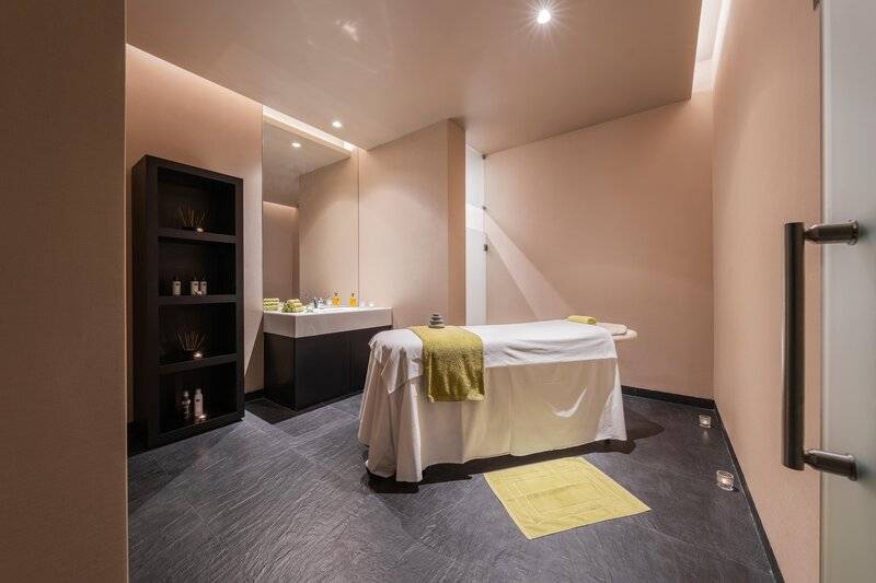 Das Innere des Wellnessbereichs im The Views Baia Hotel mit einer Massageliege und einem Waschbecken.