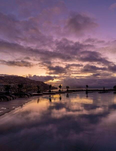 Sonnenuntergang bei The Views Baia mit reflektierten Lichtern im Pool