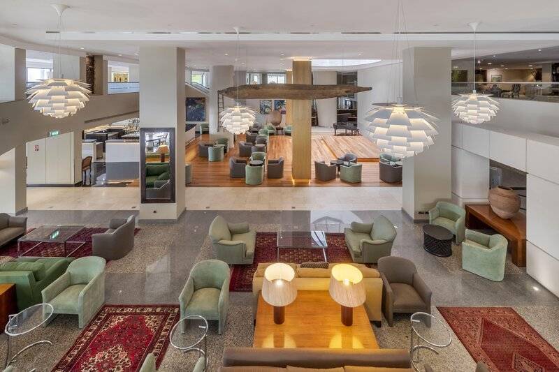 Innenansicht der Lobby des Royal Savoy Hotels mit Möbeln, Teppichen und Lampen.