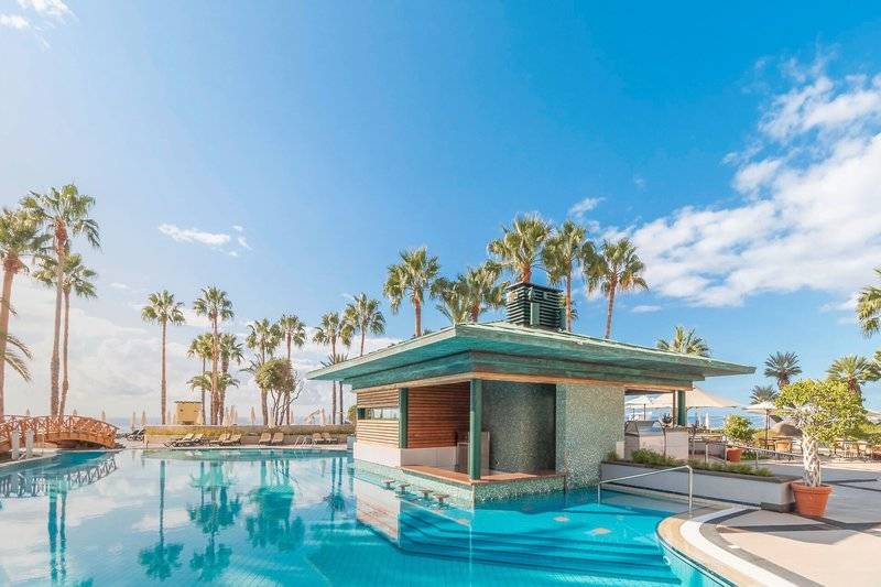 Pool-Bar des Royal Savoy Hotels mit Palmen und Meer im Hintergrund