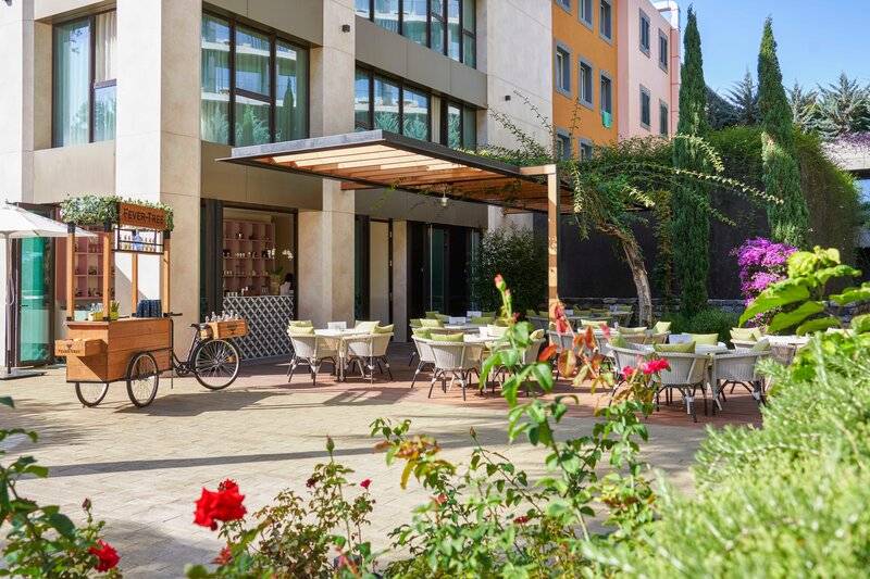 Außenbereich des Savoy Palace Hotels mit Garten, Terrasse und Tischen