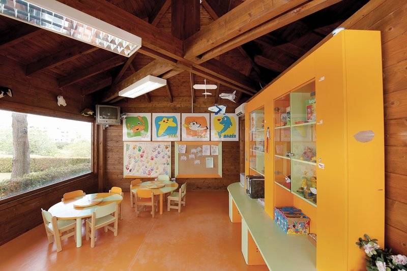 Kinderzimmer im Vila Galé Cerro Alagoa Hotel mit gelben Möbeln und bunten Wandbildern.