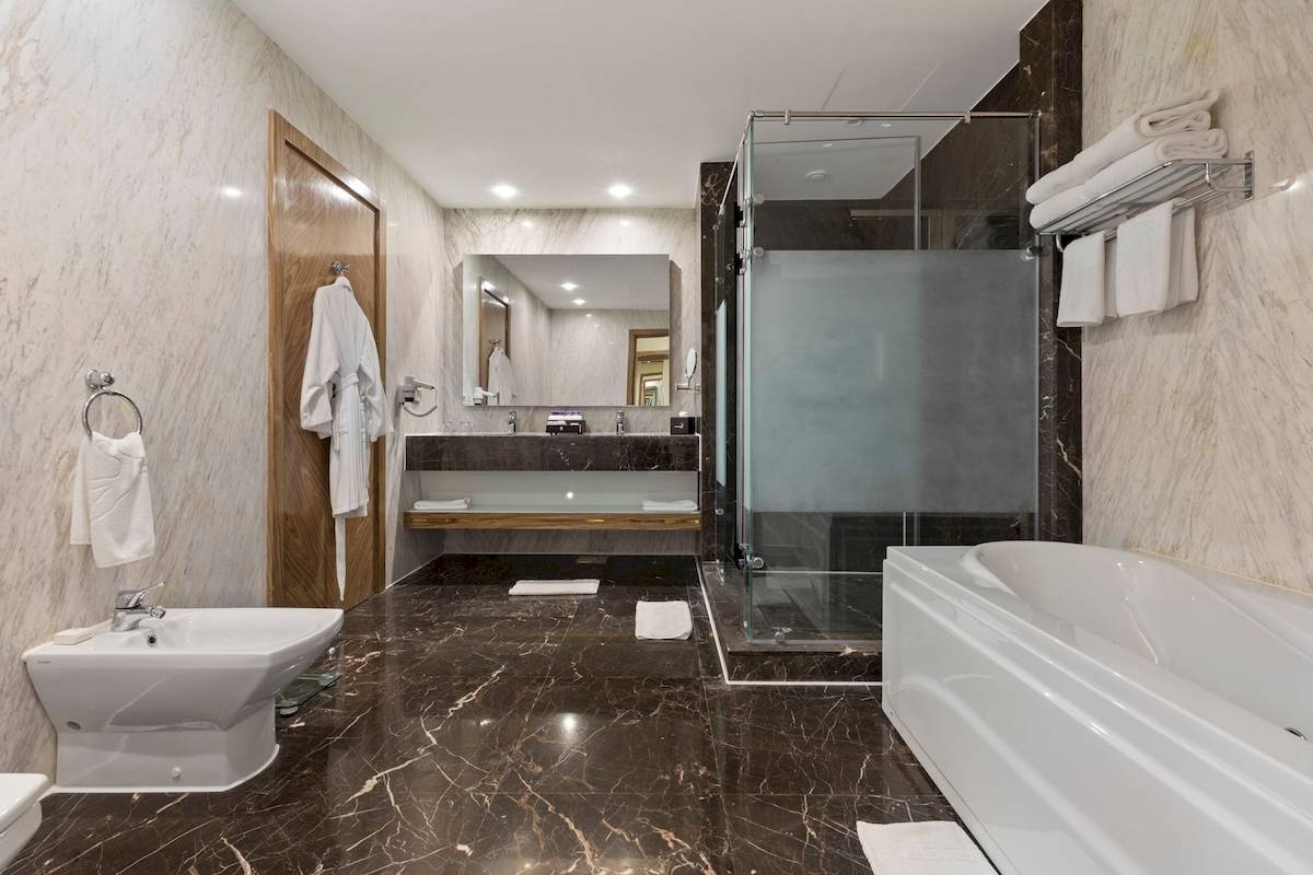 Badezimmer im Pickalbatros Citadel Resort mit Badewanne, Dusche, Waschbecken und Spiegel.