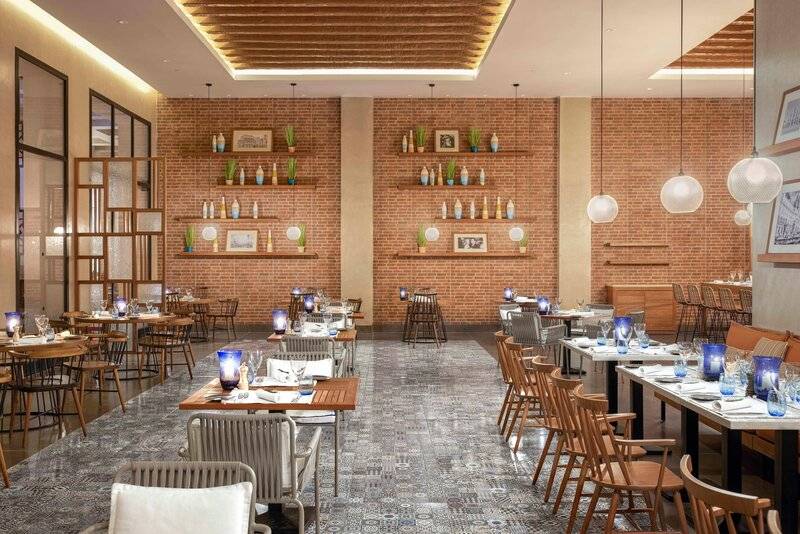 Innenansicht des Restaurants im Steigenberger Resort Alaya mit gefliesten Wänden und Holzmöbeln.