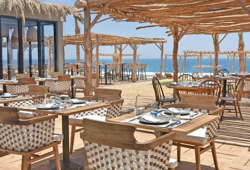 Außenterrasse eines Hotels am Strand mit Blick auf das Meer