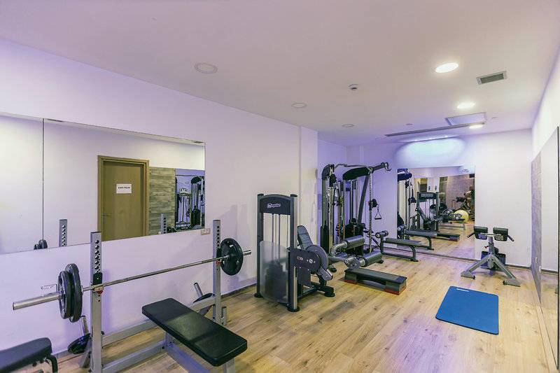 Fitnessstudio im Asterias Beach Resort mit verschiedenen Geräten und Spiegeln