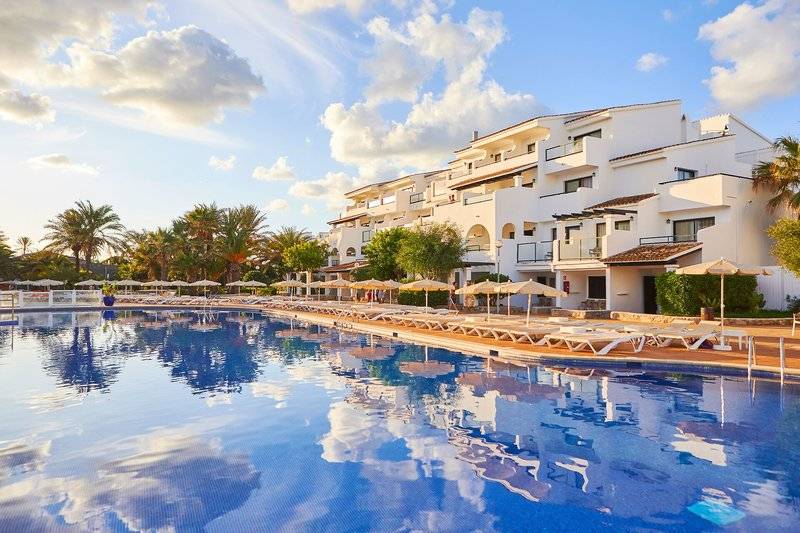 Ein Swimmingpool vor dem Hotel Fergus Style Bahamas mit Sonnenliegen und Sonnenschirmen