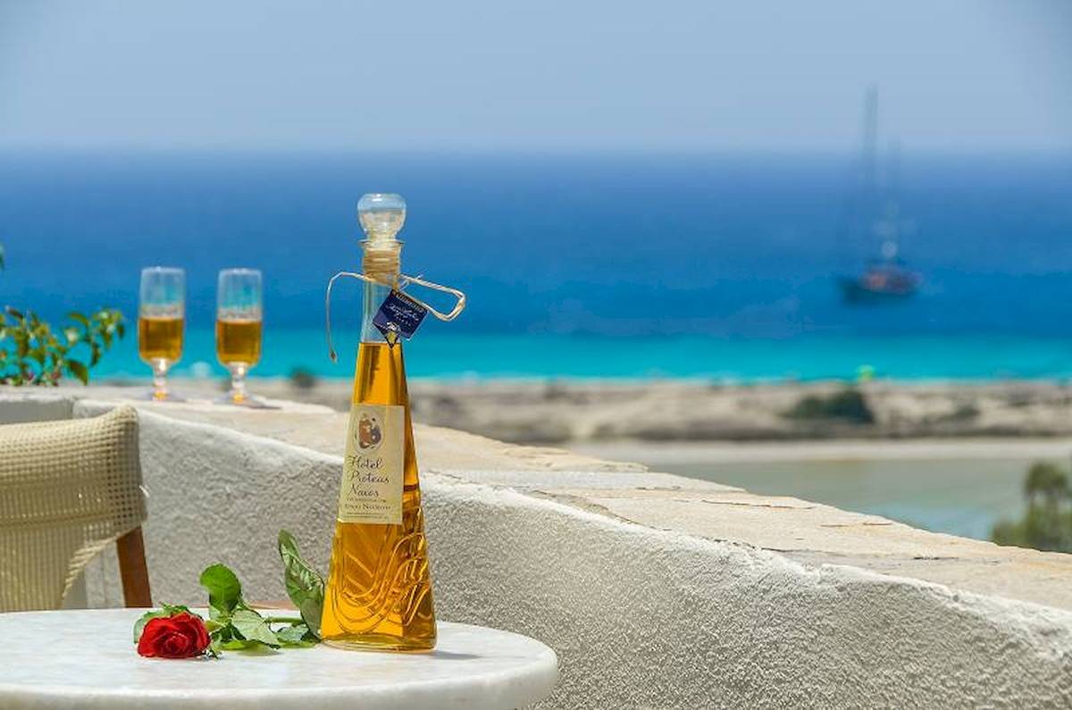 Terrasse im Proteas Hotel & Suites mit Aussicht auf das Meer und einem Glas Wein