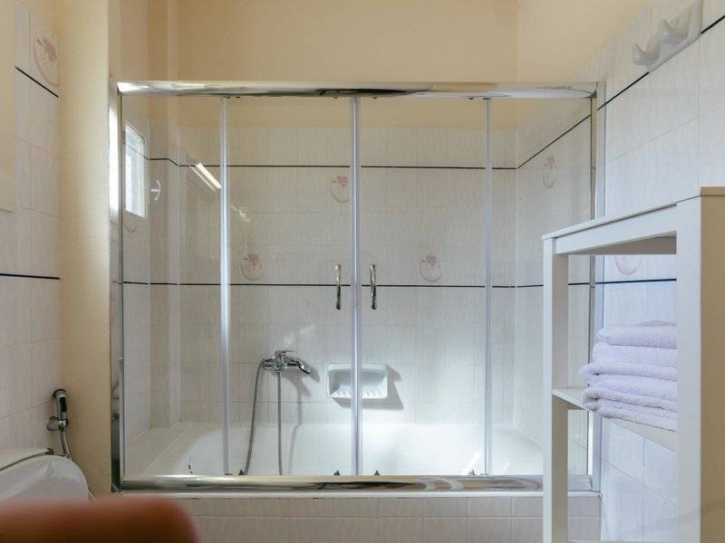 Badezimmer im Mikri Vigla Hotel mit Glasdusche und Badewanne