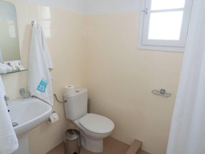 Badezimmer im Amaryllis Paros Beach Hotel mit Toilette, Waschbecken und Spiegel.