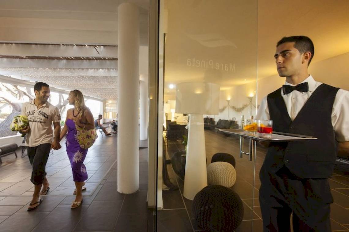 Ein Mitarbeiter des Mare Pineta Hotels serviert Getränke an der Bar.