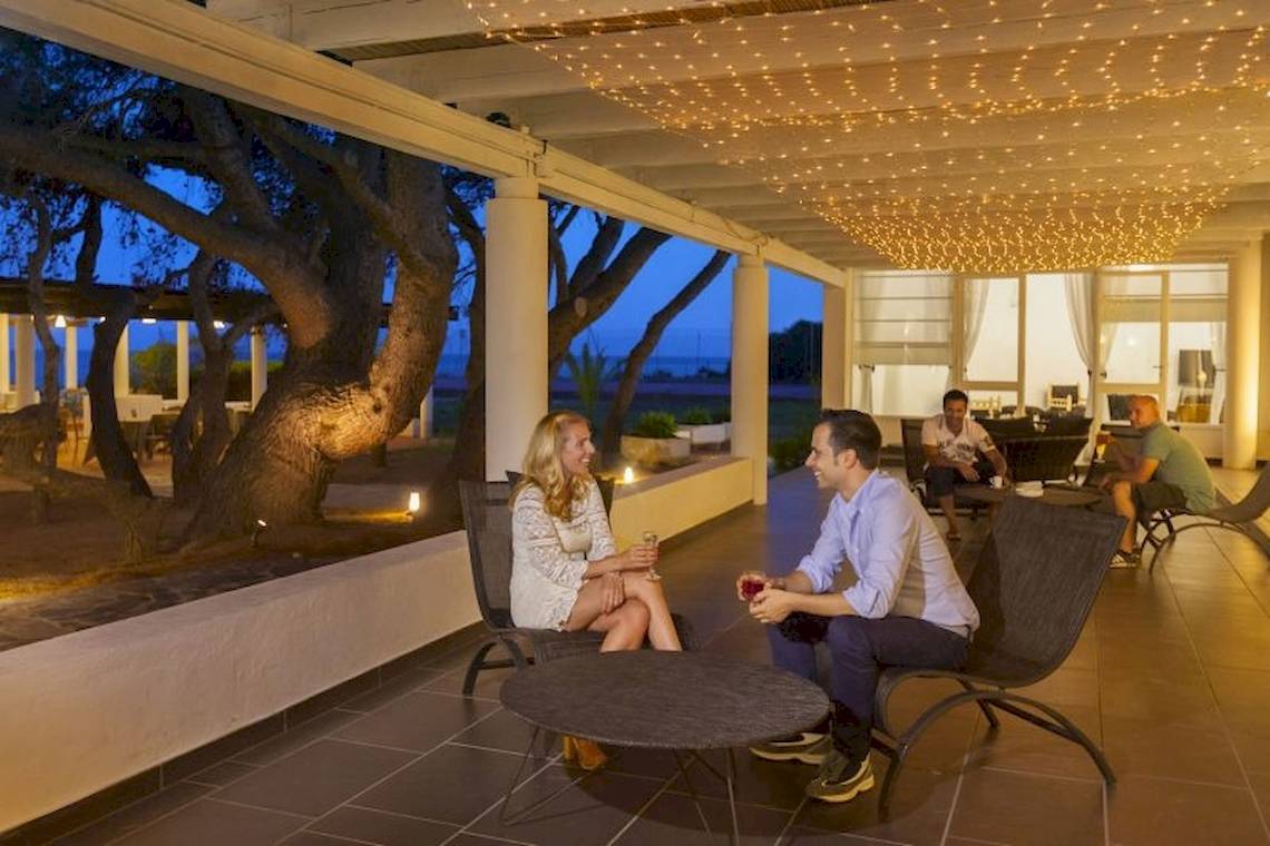 Paar sitzt auf der Terrasse des Mare Pineta Hotels bei Sonnenuntergang