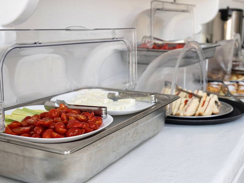 Frühstücksbuffet im Iris Boutique Hotel mit Tomaten, Käse und Sandwiches.