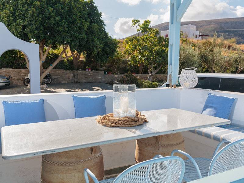 Außenansicht der Terrasse des Pyrgaki Hotels mit Tisch, Stühlen und Kissen.