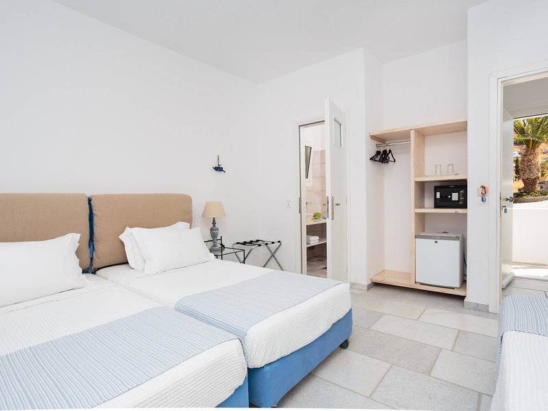 Doppelzimmer im Pyrgaki Hotel mit zwei Betten, weißen Wänden und blauen Laken.