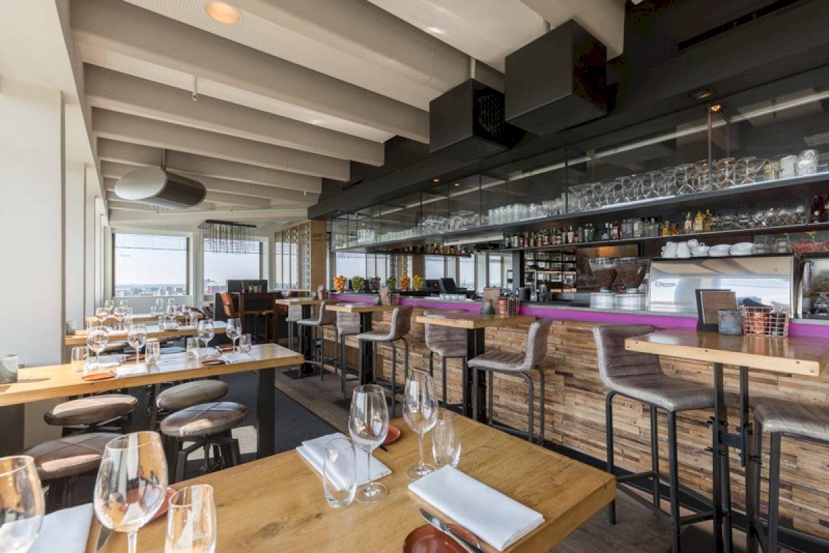 Innenansicht des Restaurants im Leonardo Hotel Amsterdam Rembrandtpark mit Tischen, Stühlen und einer Bar.