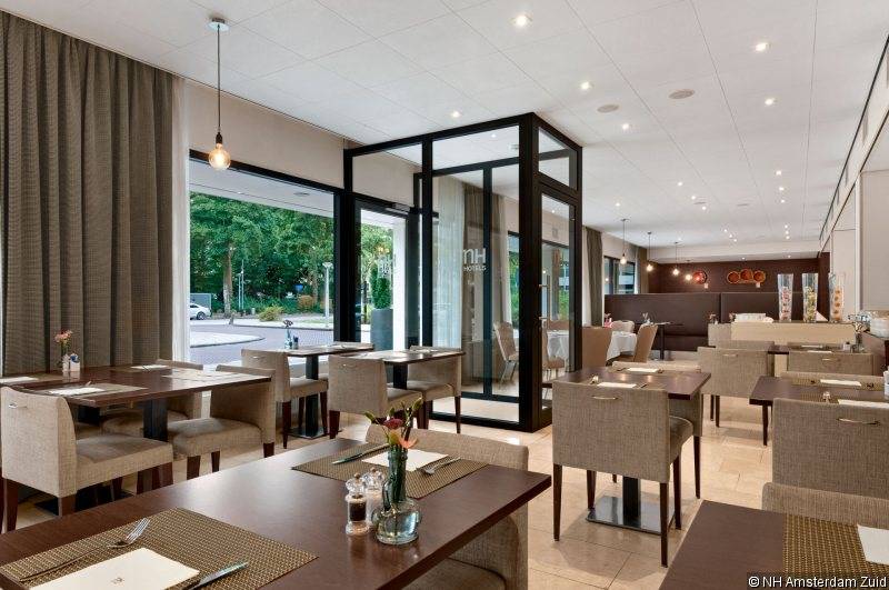 Restaurant des NH Amsterdam Zuid Hotels mit Tischen und Stühlen, Blick auf die Straße