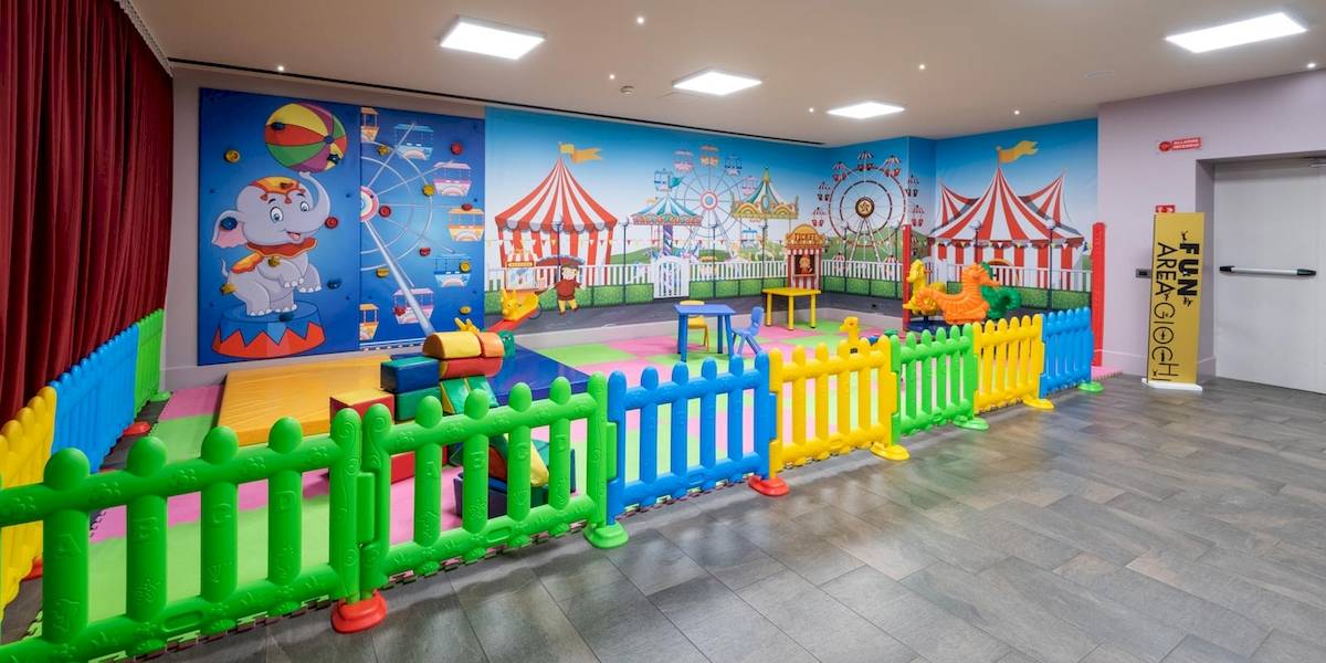 Spielbereich für Kinder im A.Roma Lifestyle Hotel mit bunten Spielgeräten und einer bunten Wandgestaltung.