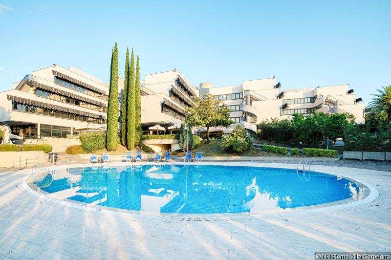 Außenbereich des NH Roma Villa Carpegna Hotels mit Swimmingpool und Sonnenliegen