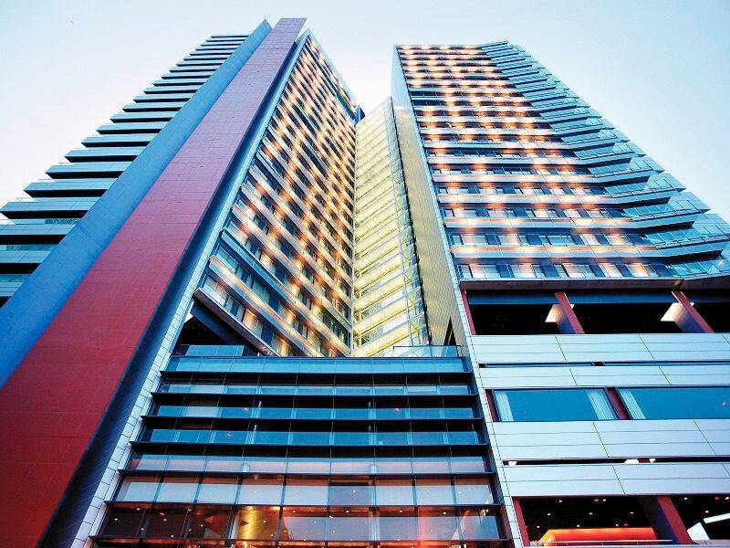 Außenansicht des Barcelona Princess Hotels, das hell beleuchtet ist und viele Fenster hat.