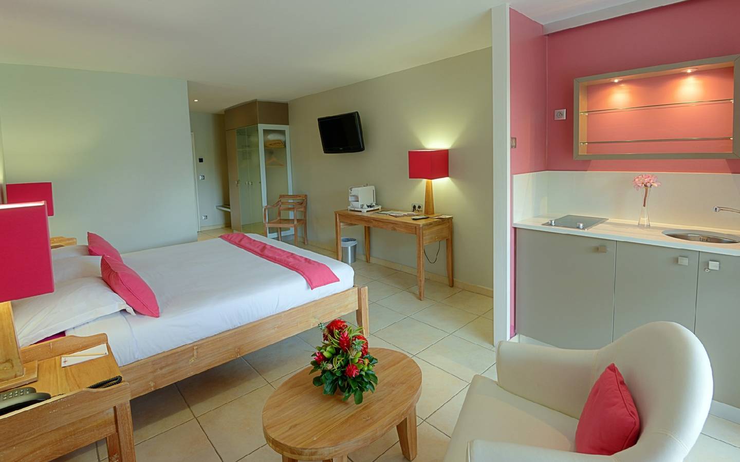 Zimmer im La Pagerie Tropical Garden Hotel mit Bett, Schreibtisch, Stuhl und Deko.