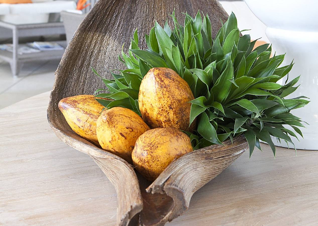 Ein Zimmer im La Pagerie - Tropical Garden Hotel mit einer großen Holzschale, die Früchte und Pflanzen enthält.