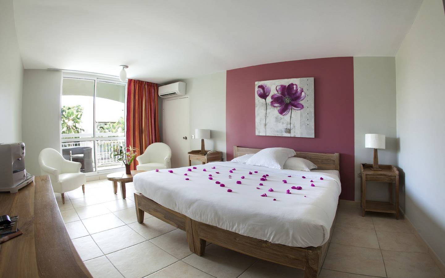 Schlafzimmer im La Pagerie - Tropical Garden Hotel mit Blumenblättern auf dem Bett