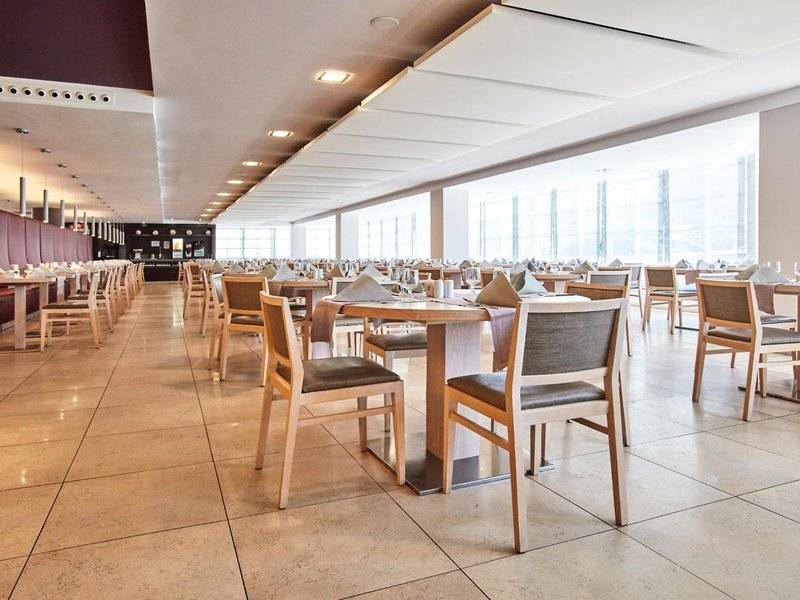 Innenansicht des Restaurants im Beach Club Font de Sa Cala mit vielen Tischen und Stühlen.