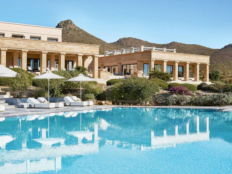 Außenpool mit Lounge-Liegestühlen und weißen Sonnenschirmen vor dem Cape Sounio Grecotel Resort.