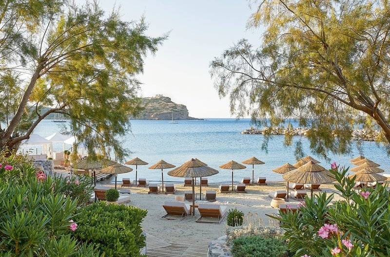 Strandbereich des Cape Sounio Grecotel Resorts mit Sonnenschirmen und Lounge-Sesseln