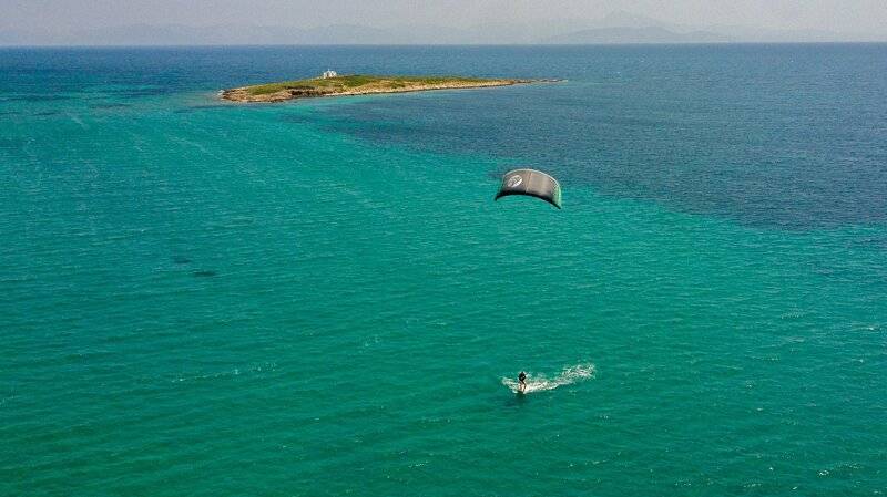 Luftbild eines Paraseglers im Meer vor einer Insel, Hotelname Dolce Athens Attica Riviera