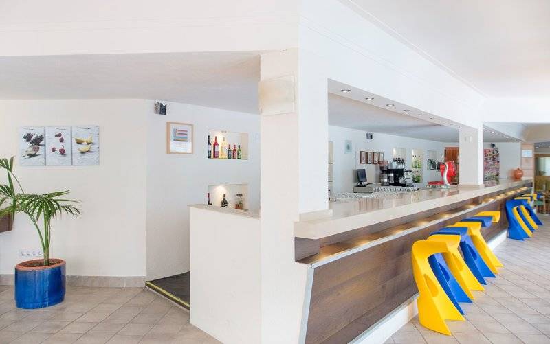 Rezeption im La Santa Maria Playa Hotel mit modernem Design und bunten Stühlen.