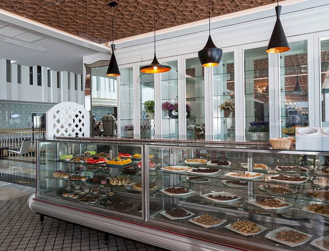 Im Sultan of Dreams Hotel zeigt eine Vitrine eine Auswahl an süßen Desserts.