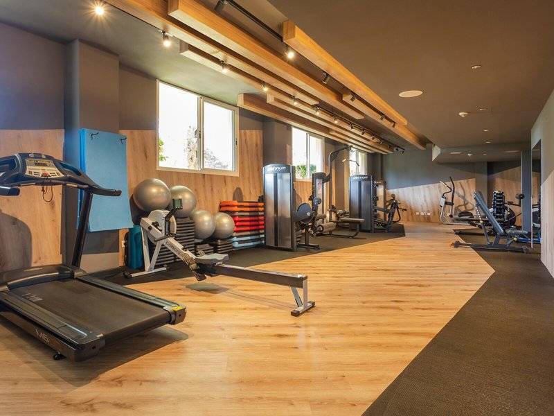 Fitnessraum im Aparthotel Marins Playa mit Laufband, Gewichten und Geräten.