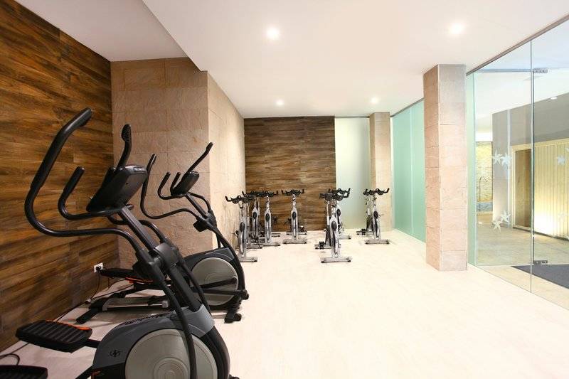 Fitnessbereich im Iberostar Cala Millor Hotel mit Cardiogeräten und Glaswänden