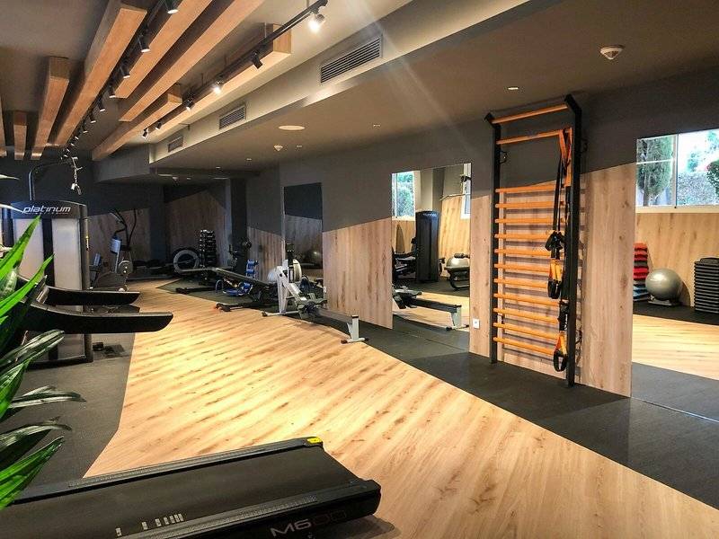 Fitnesscenter im Marins Playa Suites Hotel mit modernen Geräten und Holzboden.