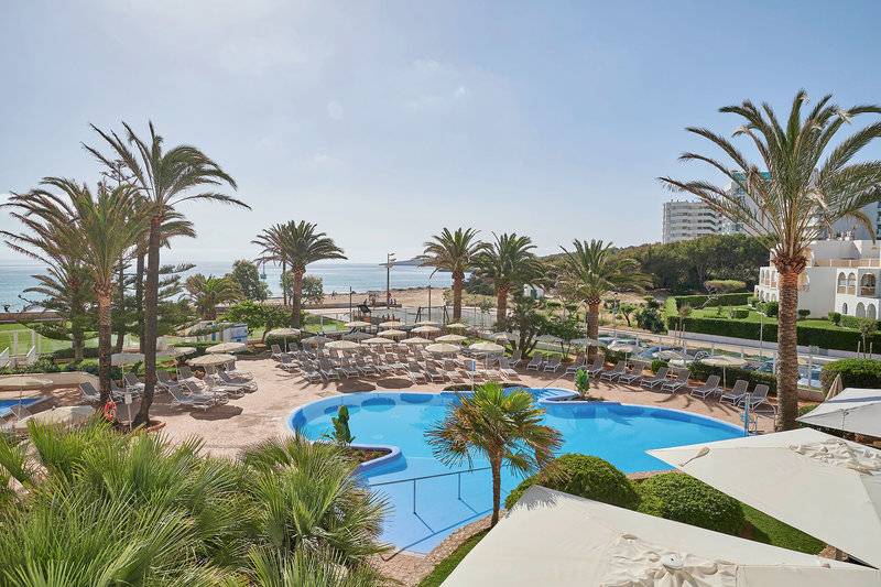 Ausblick auf den Poolbereich des Hipotels Dunas Cala Millor mit Palmen und Sonnenliegen.