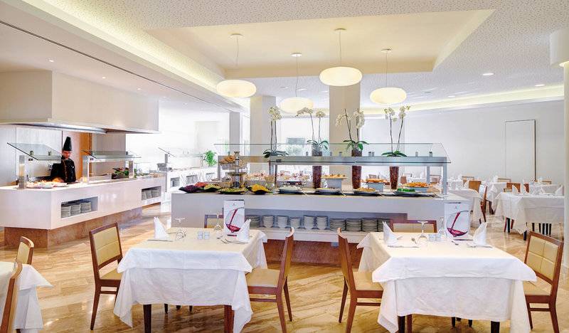 Restaurant im Hipotels Dunas Cala Millor mit Buffet und gedeckten Tischen.