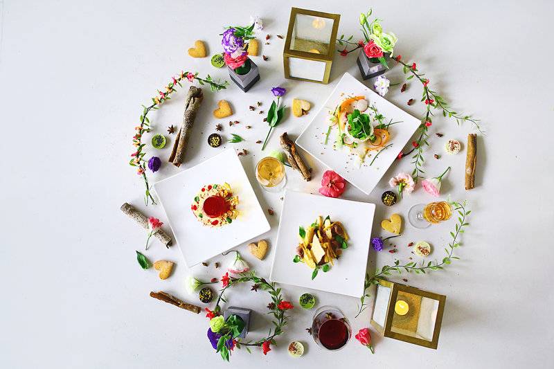 Frisch zubereitete Gerichte im TIA Wellness Resort, umgeben von Blumen und Kerzen.