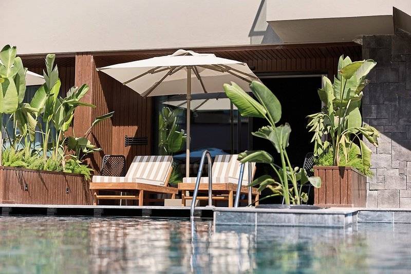 Pool-Lounge-Bereich im Aldiana Club Side Beach Hotel mit Sonnenliegen und Schirmen.